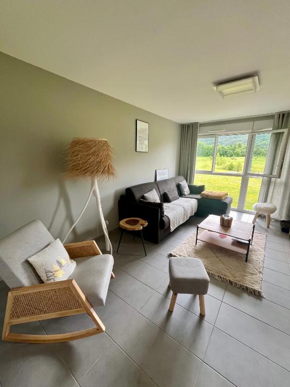 un salon avec un canapé et une table dans l'établissement Appartement au Golf Barcelonnette, à Barcelonnette