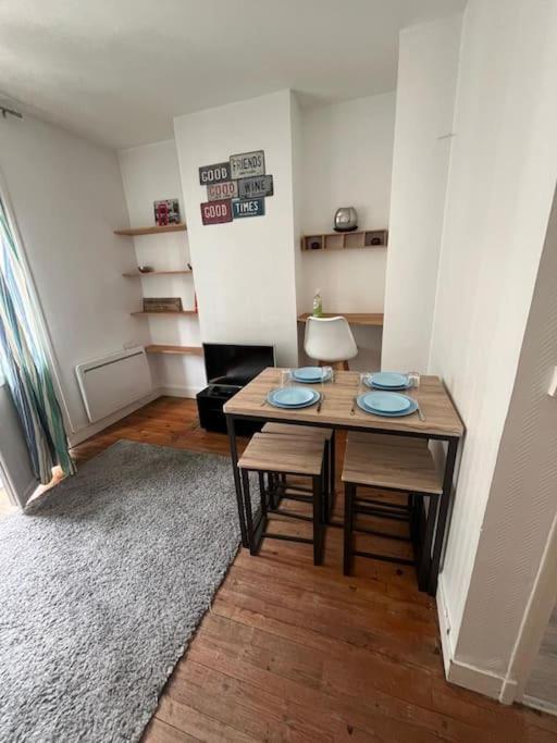 Cette chambre comprend une table, deux chaises et un tapis. dans l'établissement Le Chaleureux, au Havre