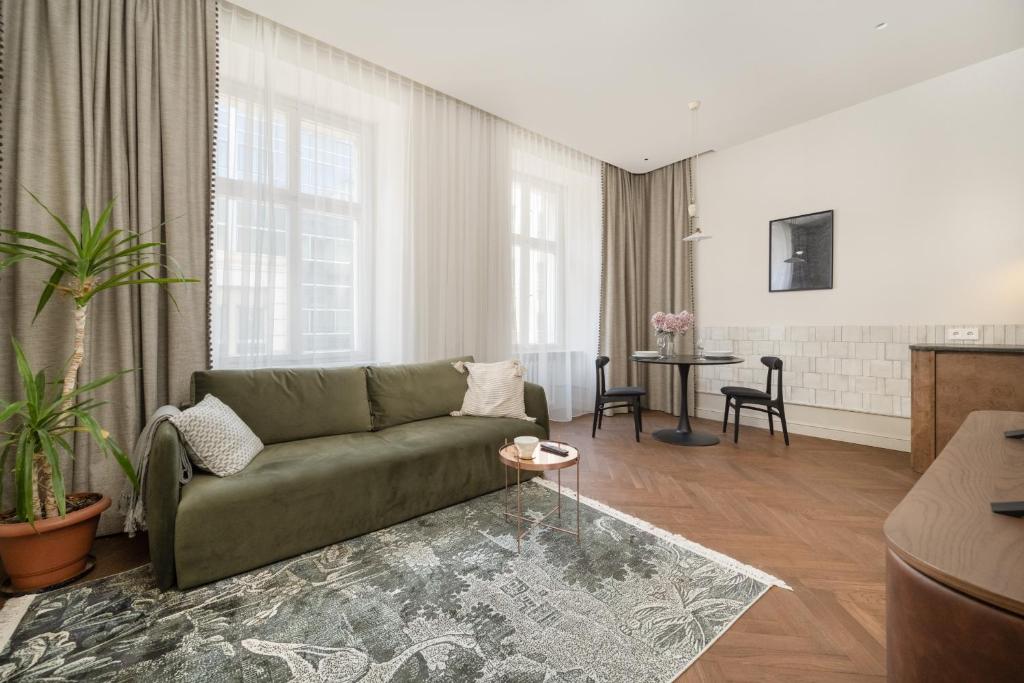 un salon avec un canapé vert et une table dans l'établissement Stylowy Apartament przy Rynku Głównym we Wrocławiu by Rent like home, à Wrocław