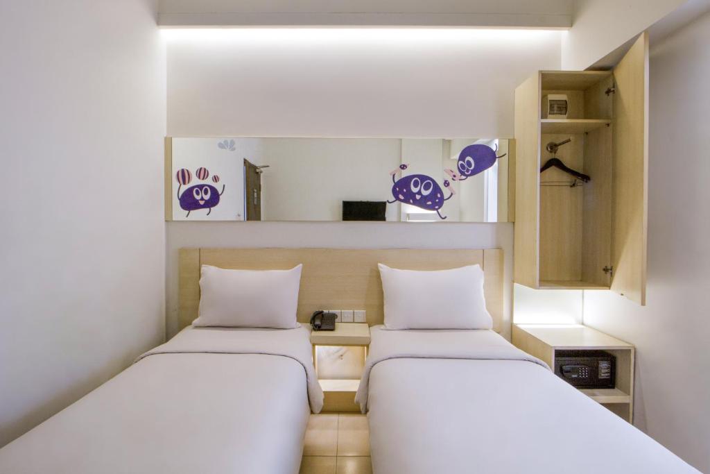 Postel nebo postele na pokoji v ubytování Cleo Hotel Tunjungan