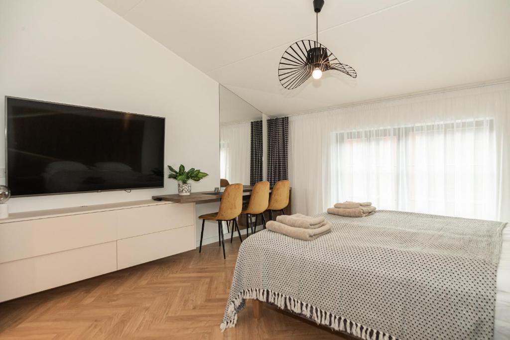 a white bedroom with a large flat screen tv at Uus Volta in Tallinn