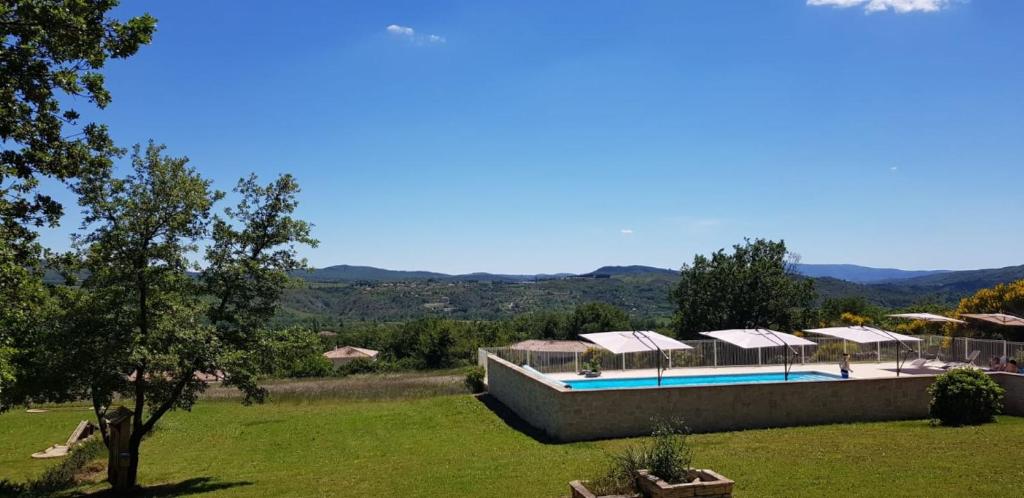une maison avec une piscine dans un champ dans l'établissement Domaine de la Chêneraie, à Mirabel