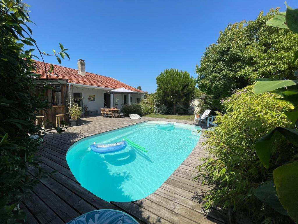 une piscine dans l'arrière-cour d'une maison dans l'établissement Maison de charme familiale Bassin Arcachon, à La Teste-de-Buch