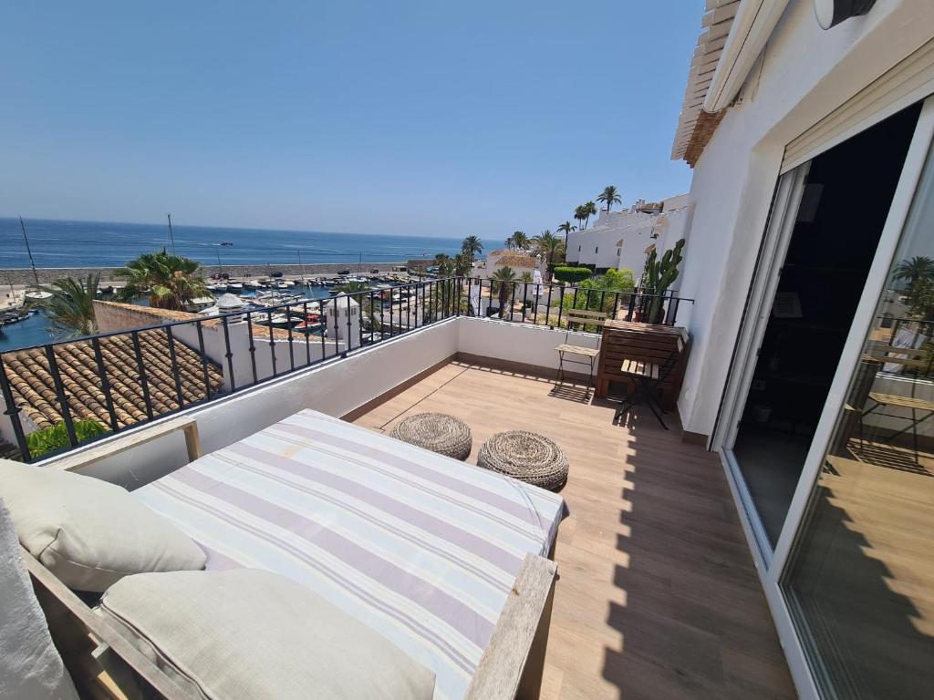 balcón con sofá y vistas al océano en Sunny Getaway, en La Herradura