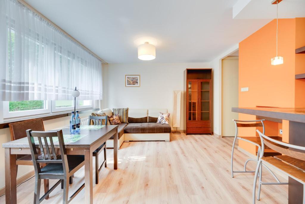 une cuisine et un salon avec une table et des chaises dans l'établissement Orange by OneApartments, à Gdańsk