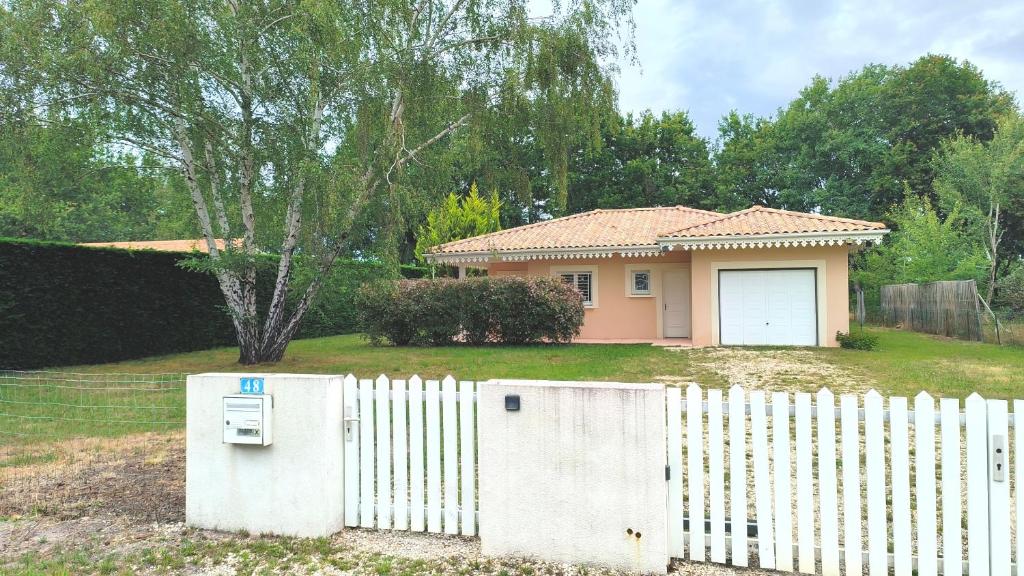 une clôture blanche devant une maison dans l'établissement La Villa des Pins Confort pour 6 personnes, à Andernos-les-Bains