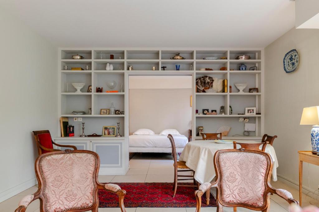 une pièce avec une table et des chaises et une chambre dans l'établissement Veeve - The Garden of La Muette, à Paris