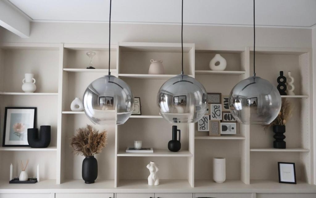 une pièce avec trois boules de verre suspendues à une étagère dans l'établissement Appartement vue sur seine, à Courbevoie