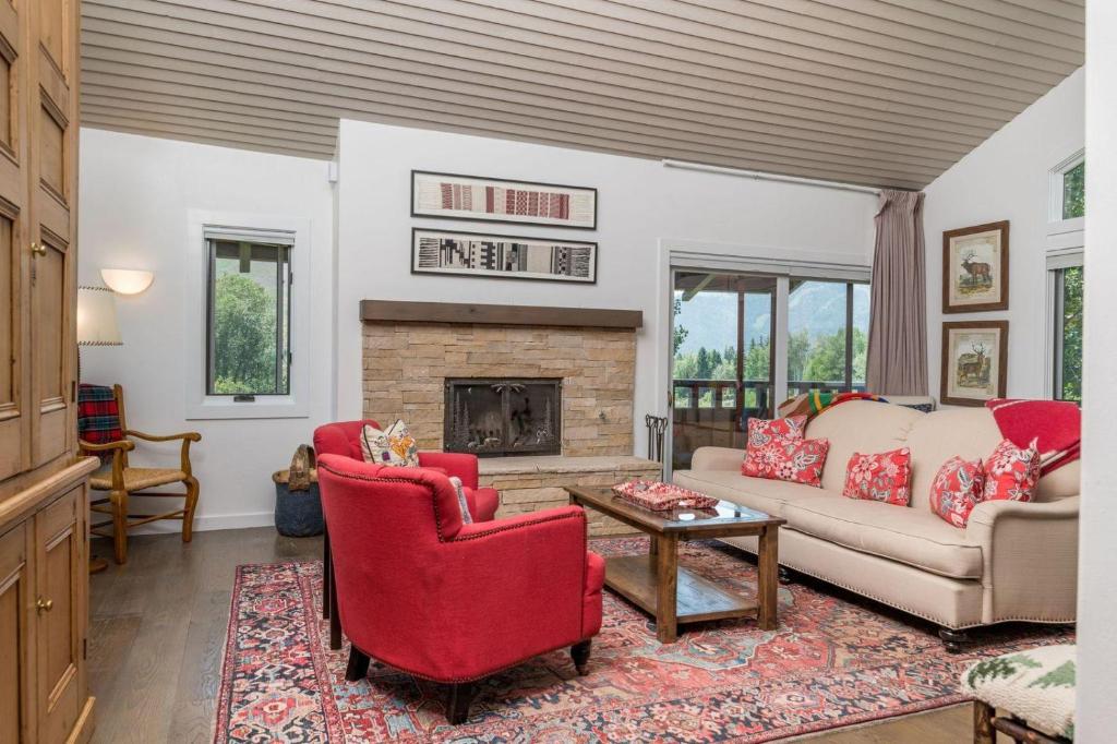 un salon avec des chaises rouges et une cheminée dans l'établissement Wildflower Condo 679, à Sun Valley