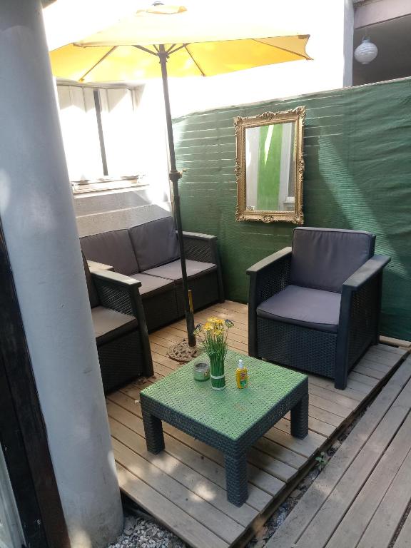 une terrasse avec des chaises, un parasol et une table dans l'établissement Le Loft 3, à Montpellier