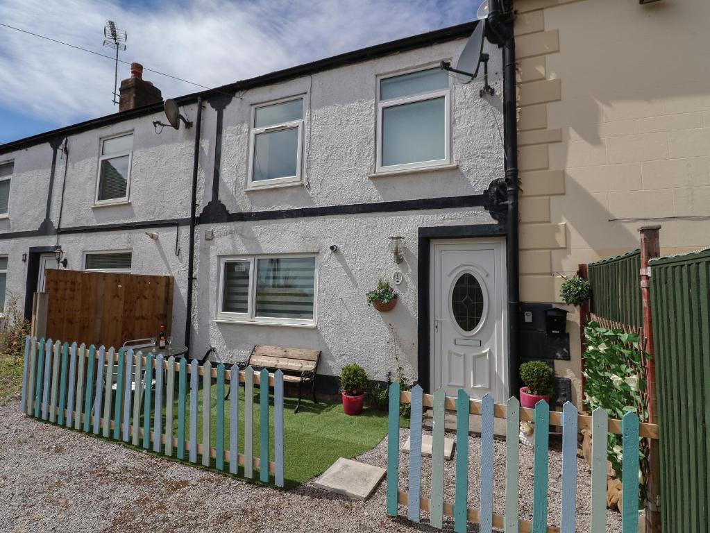 Un uomo seduto sul tetto di una casa di 2 Stoneleigh Cottage a Wrexham