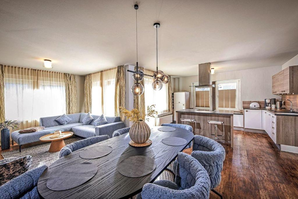 ein Wohnzimmer mit einem Tisch und blauen Stühlen in der Unterkunft Edelweiss Appartements 'MÜHLENKOPF' deluxe - inkl Wellness-Spa und MeineCardPlus in Willingen