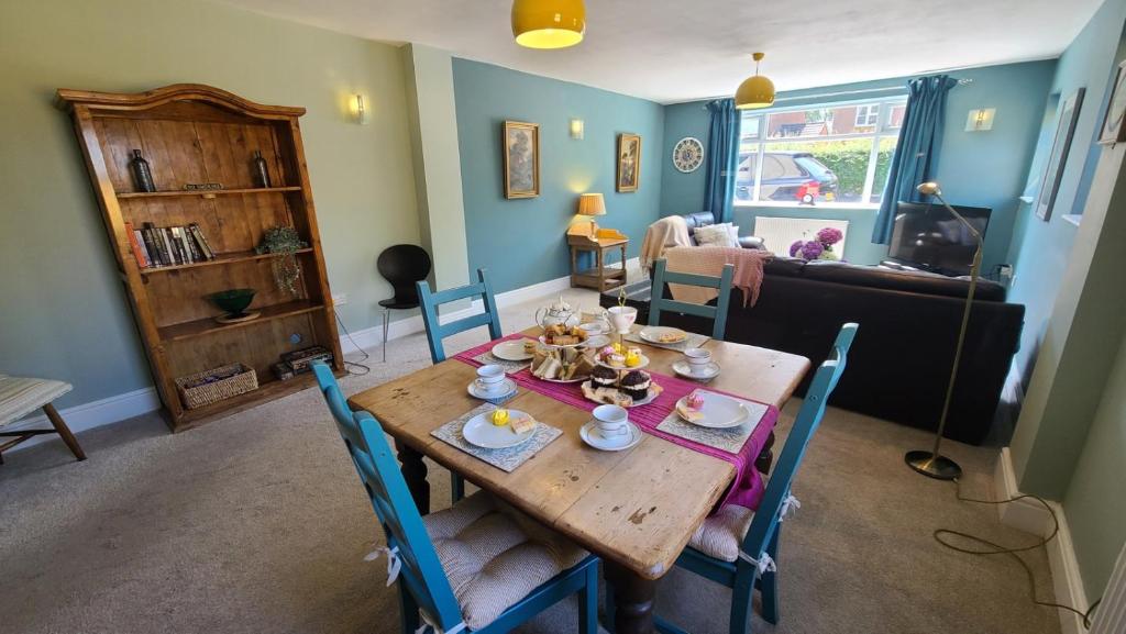 a dining room with a wooden table and chairs at The Lodge a beautiful barn conversion with 3 ensuite bedrooms on the edge of Cannock Chase in Hednesford