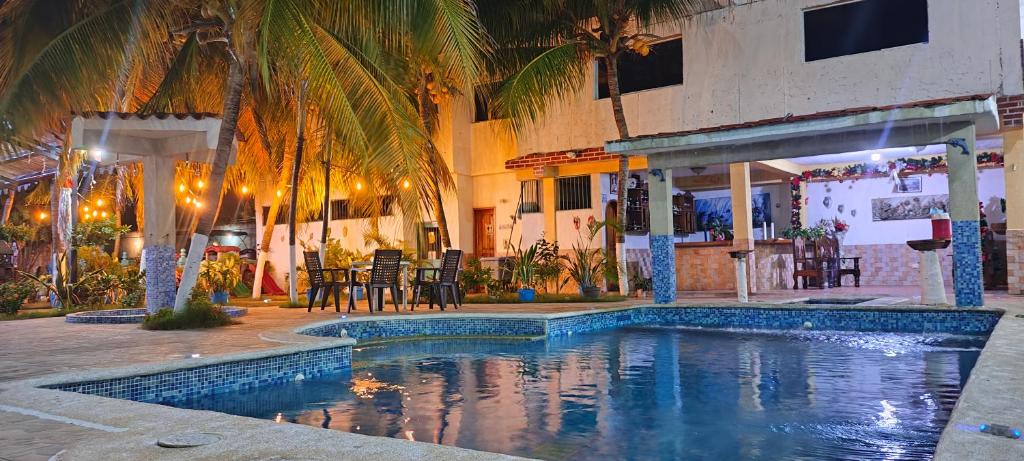 una piscina di fronte a un edificio con palme di Buzios Posada a Chichiriviche