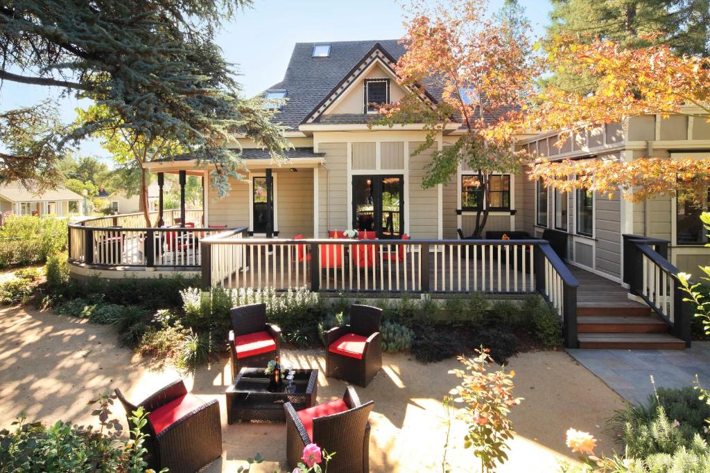 een huis met een veranda met stoelen en een patio bij The Grape Leaf Inn in Healdsburg