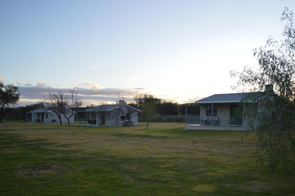 una casa in un campo con un cortile di Mayfair Farm Cottages a Oudtshoorn