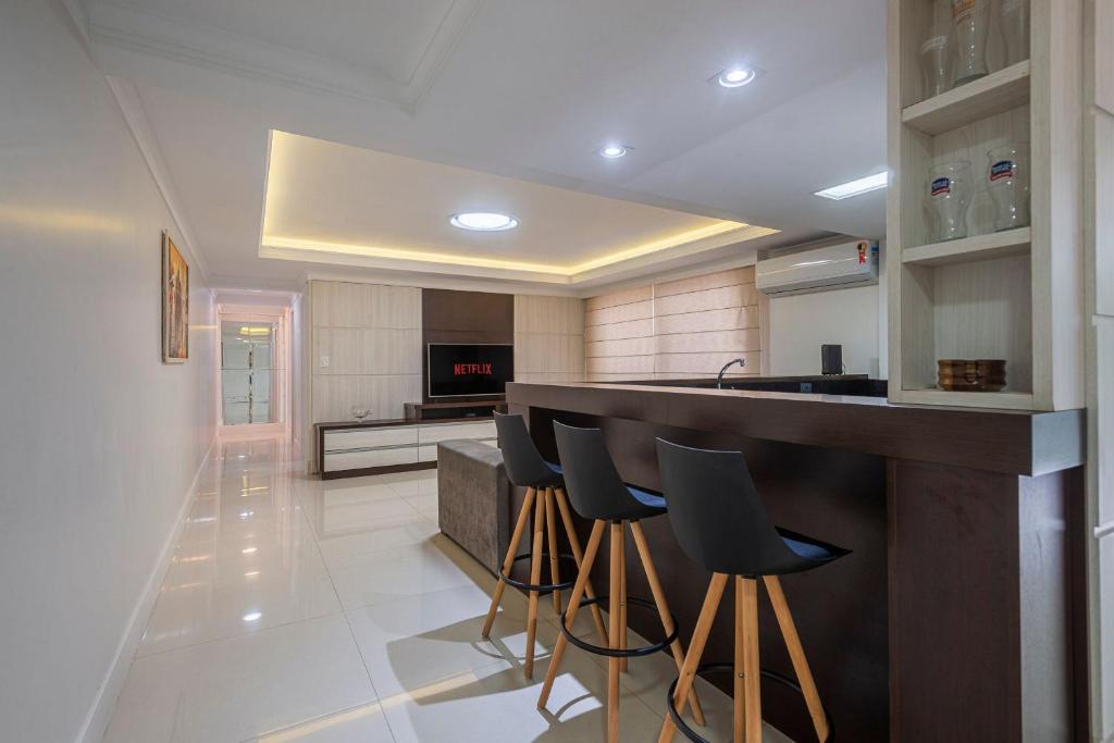 eine Küche mit einer Bar mit Hockern in der Unterkunft GRJA012- Apê na Atlântica com terraço privilegiado in Balneário Camboriú