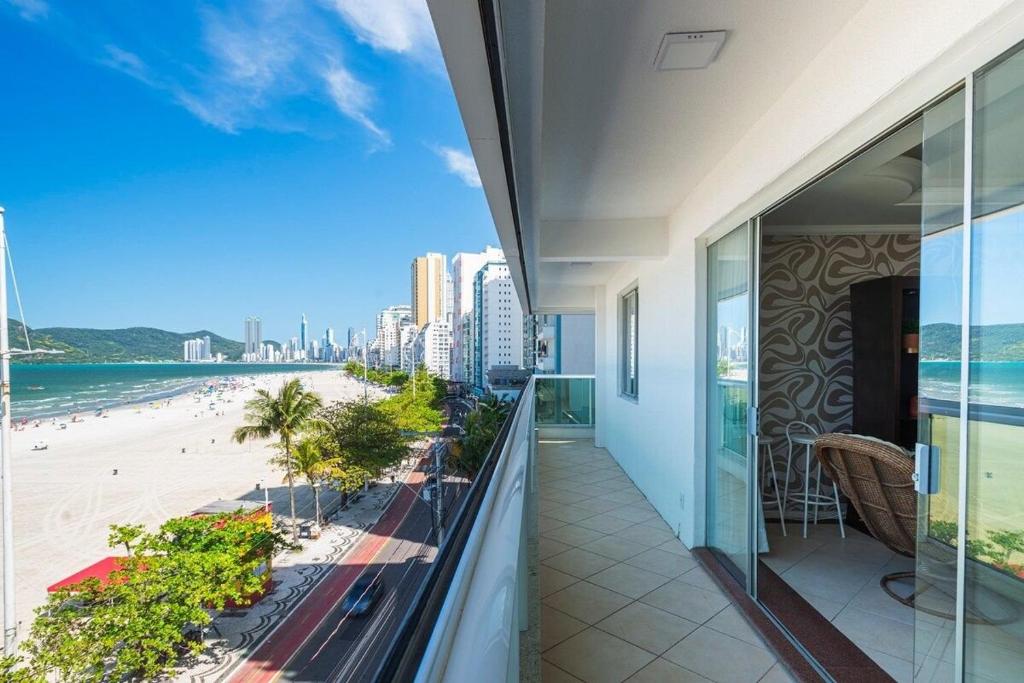 einen Balkon mit Blick auf den Strand und die Gebäude in der Unterkunft GRJA051- Incrível vista mar | Localização perfeita in Balneário Camboriú