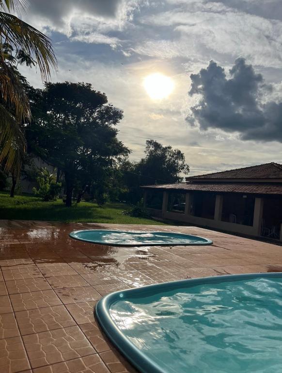 two pools of water sitting on a patio with a house at Pousada Keluz in Olímpia