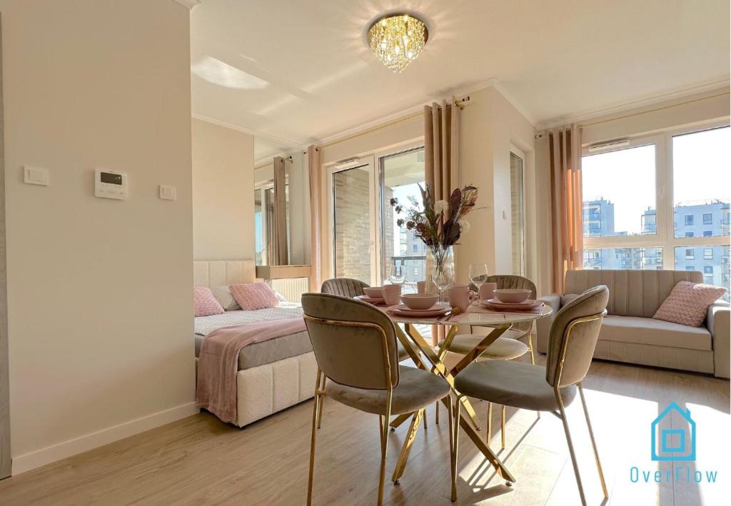 グダニスクにあるLaura Apartment with Sauna & Gym, 5 Min to Baltic Sea & Polsat Plus Arenaのテーブルとベッドのあるリビングルーム