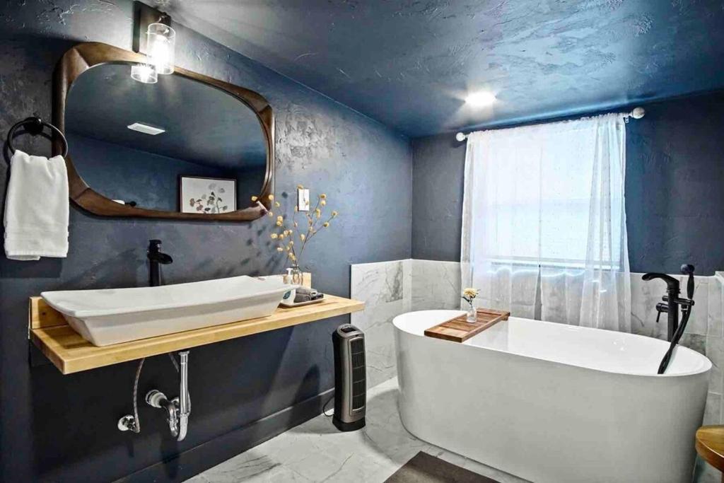 a bathroom with a tub and a large mirror at Uptown Studio Soaking Tub & Private Yard #04 in Oklahoma City