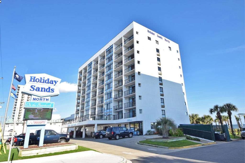 a white building with a hotel sign in front of it at Holiday Sands North "On the Boardwalk" in Myrtle Beach