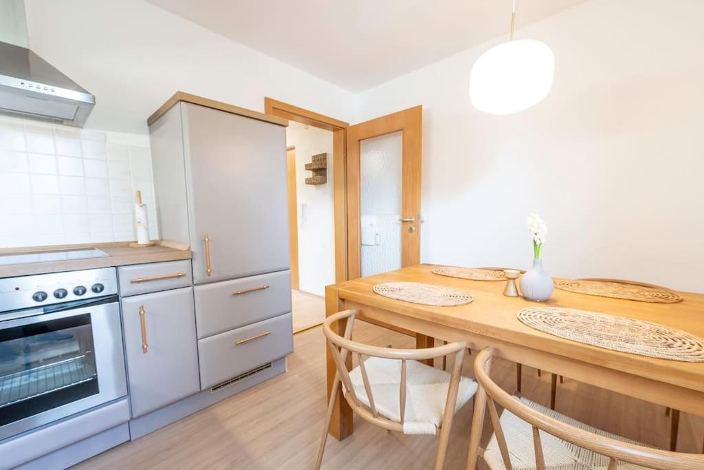 a kitchen with a wooden table with two chairs at Ferienwohnung Bergzeit in Pfronten