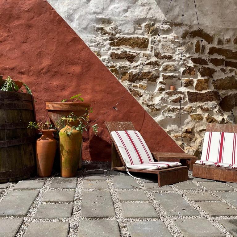 two chairs sitting on a patio next to a wall at Obidos Rural Chic House in Usseira