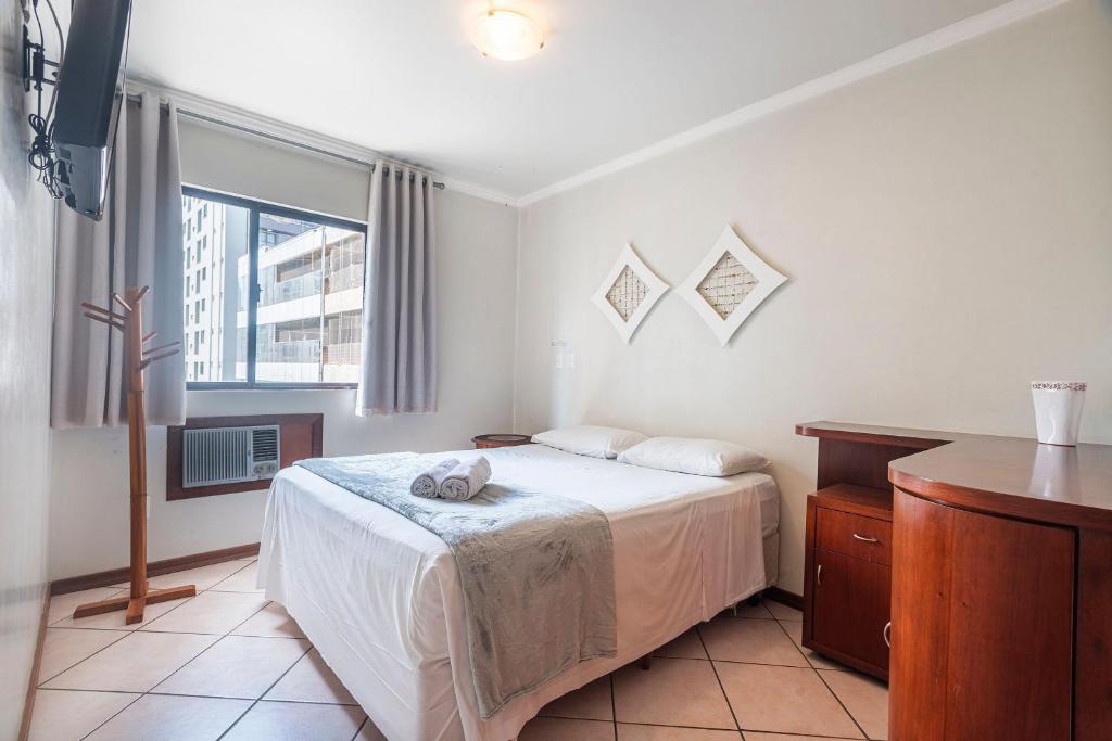 un dormitorio con una cama y una ventana en GDGT121-Conforto com 3Q+3WC+2vagas e churrasqueira, en Balneário Camboriú