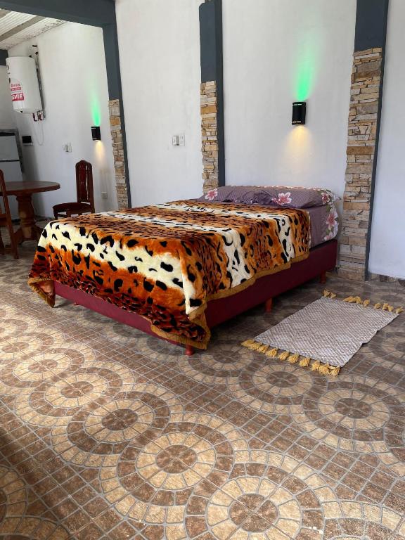 a bedroom with a bed with a leopard print blanket at Alojamiento Itaembe Guazu in Villa Dolores