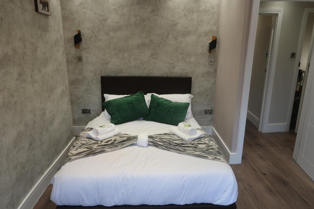 a bedroom with a large bed with green pillows at Casa Bella In Sherborne's Historic Quarterlocal in Sherborne