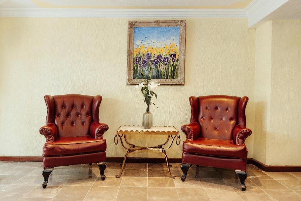 two chairs and a table in a room at Hotel Rex in Toluca