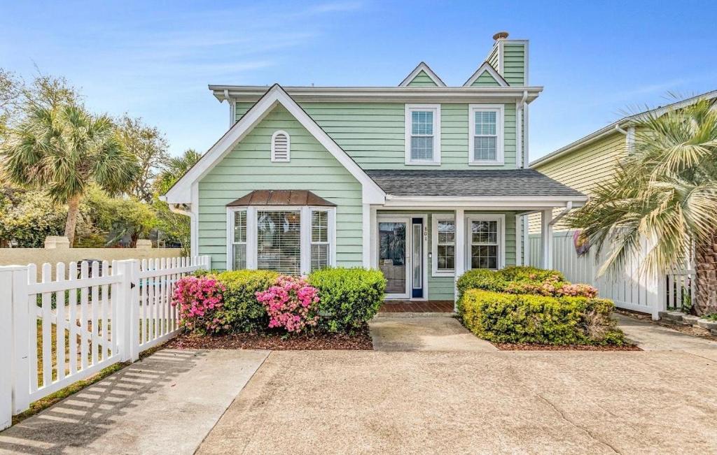a green house with a white fence at Seaside Haven in Myrtle Beach