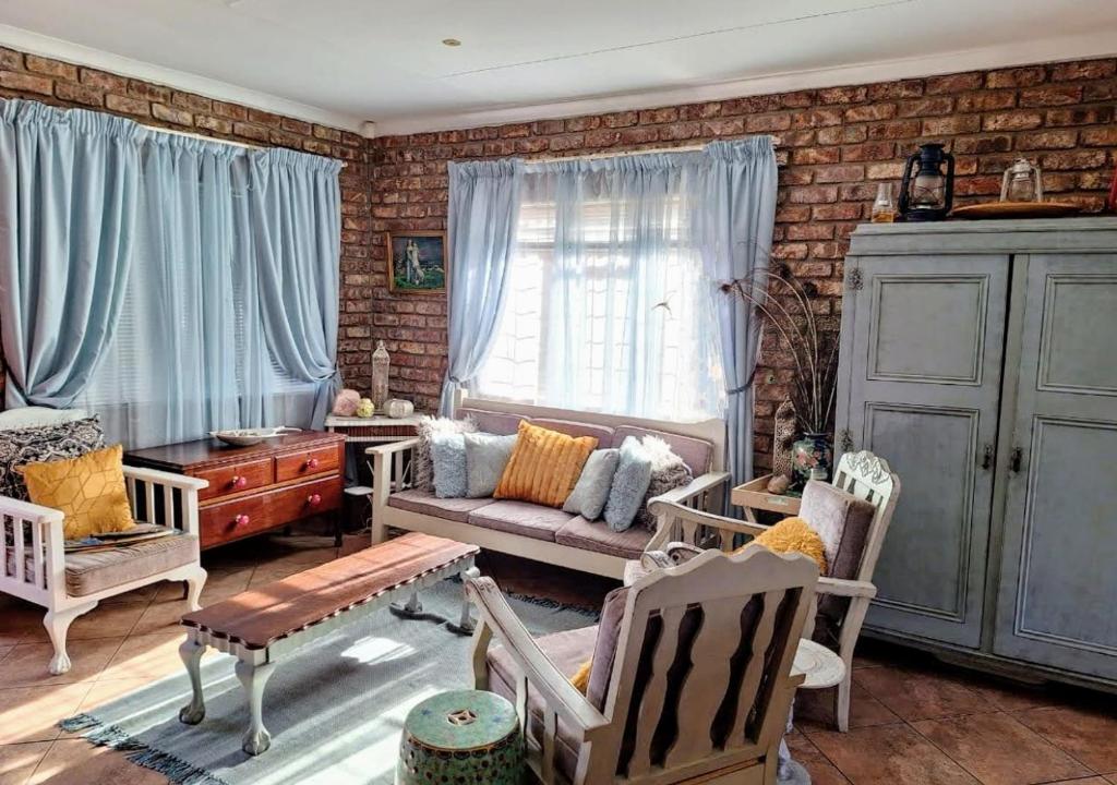 a living room with chairs and a couch and a window at Boknesstrand Self-catering Accommodation Holiday Home - a Mermaids Cottage minutes to the beach, lagoon, shops & more! in Boknes