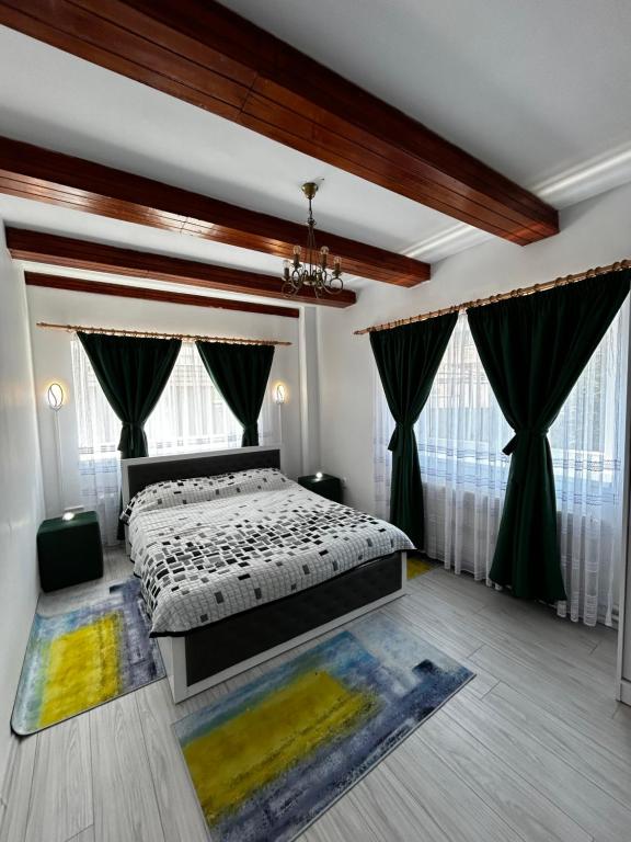 a bedroom with a bed and two windows at Casa cu brazi in Porumbacu de Sus