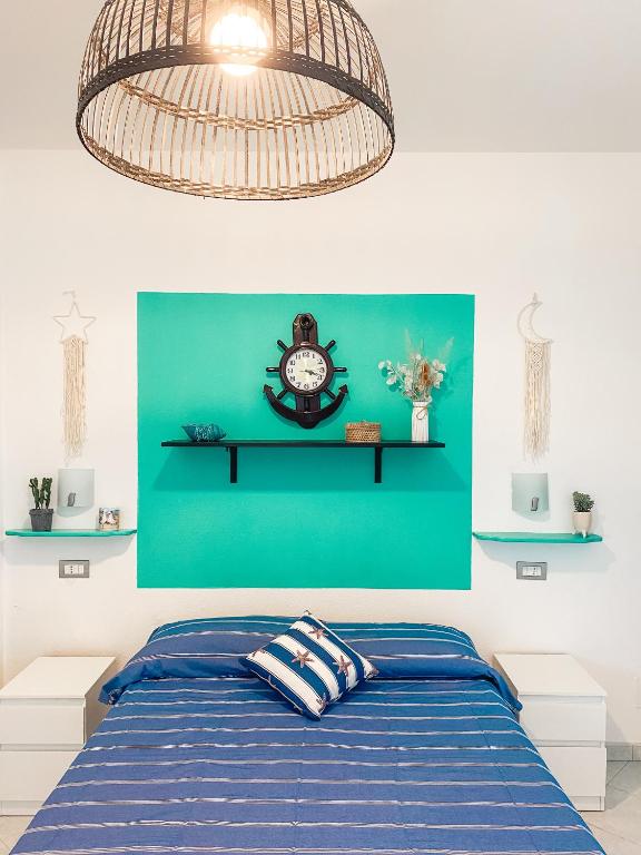 a bedroom with a bed and a clock on a green wall at Il Nido sullo Scoglio in Bonassola