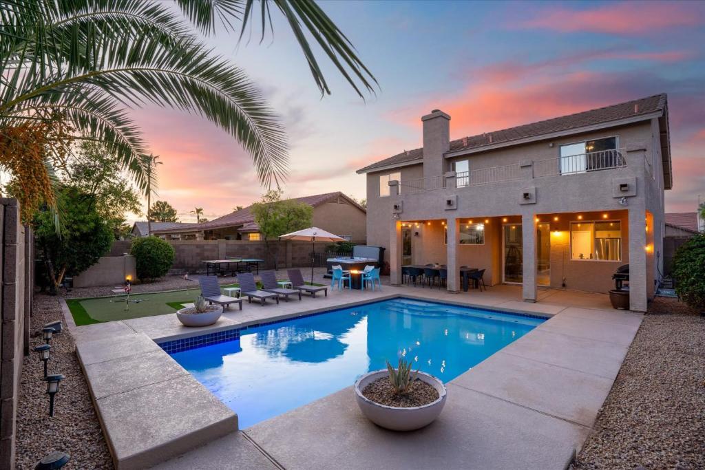 a swimming pool in front of a house at Putt Putt Hot Tub Game Room Pool Cornhole in Chandler