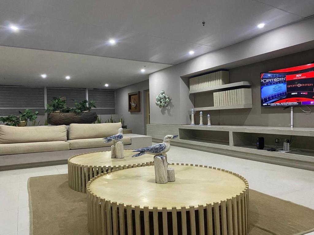 two birds sitting on a table in a living room at Apartamento salida al Mar Santa Marta in Santa Marta