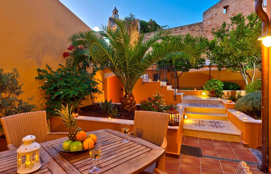 an outdoor patio with a wooden table and chairs at Kores Boutique Houses in Chania