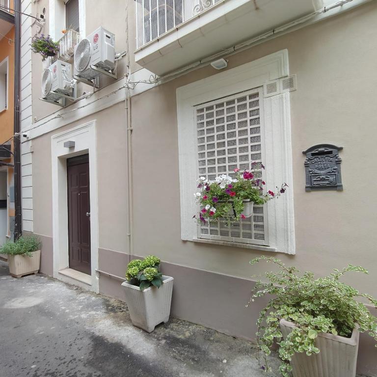 un edificio con una finestra con piante in vaso di B&B Lamezia Terme Centro a Lamezia Terme