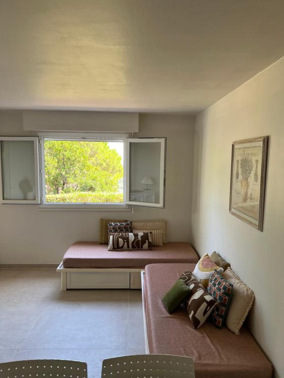 ein Zimmer mit zwei Betten und einer Couch und einem Fenster in der Unterkunft Vista in Roquebrune-sur-Argens