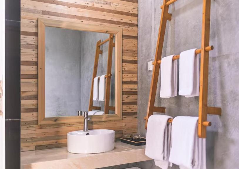 a bathroom with a sink and a mirror at Suffix Retreat - Stay, Dive & Explore Fuvahmulah in Fuvahmulah