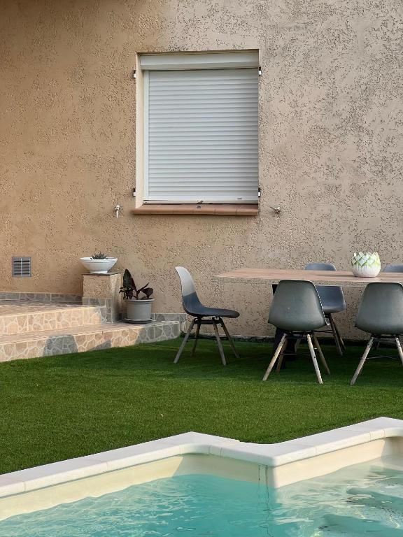 - une table et des chaises à côté de la piscine dans l'établissement Havre Provençal et sa dépendance, à Rocbaron