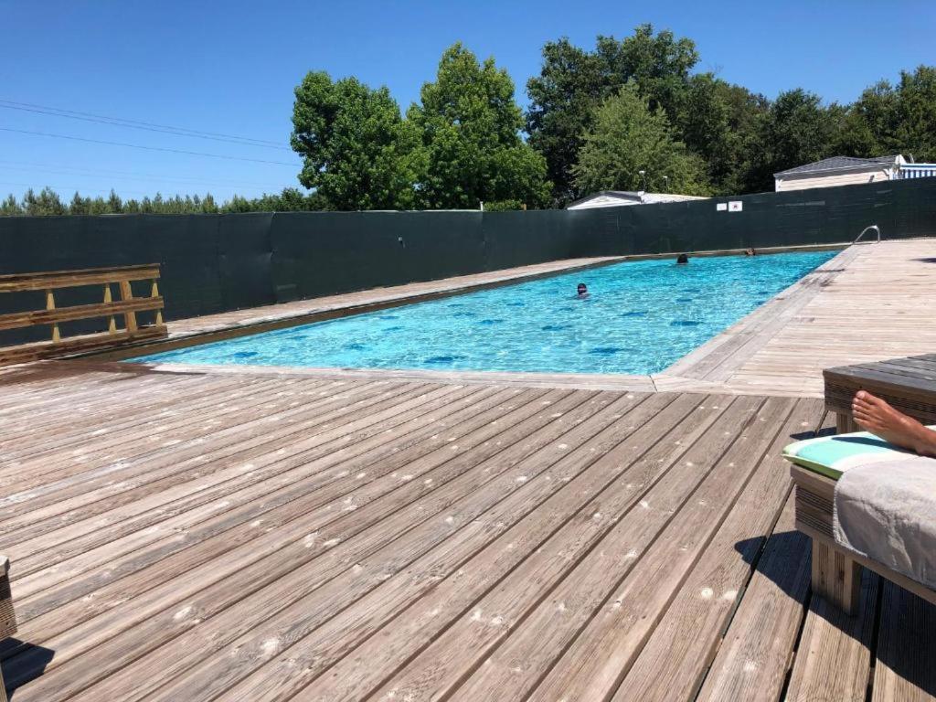 une grande piscine avec une terrasse en bois dans l'établissement MOBILHOME 40 m2 climatisé, domaine La Lande MIMIZAN, à Mimizan