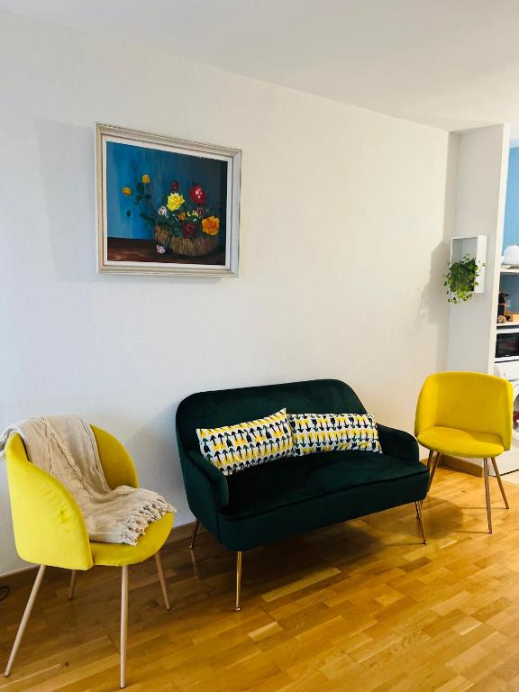 un salon avec un canapé et deux chaises dans l'établissement Studio cosy 15 mins de Paris centre, à Asnières-sur-Seine