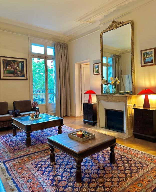 un salon avec une cheminée et un miroir dans l'établissement Champs Elysée Prestige Apartment, à Paris