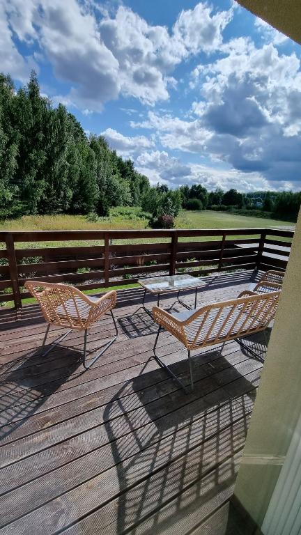 a patio with two chairs and a table on a deck at Stylowe apartamenty in Charzykowy