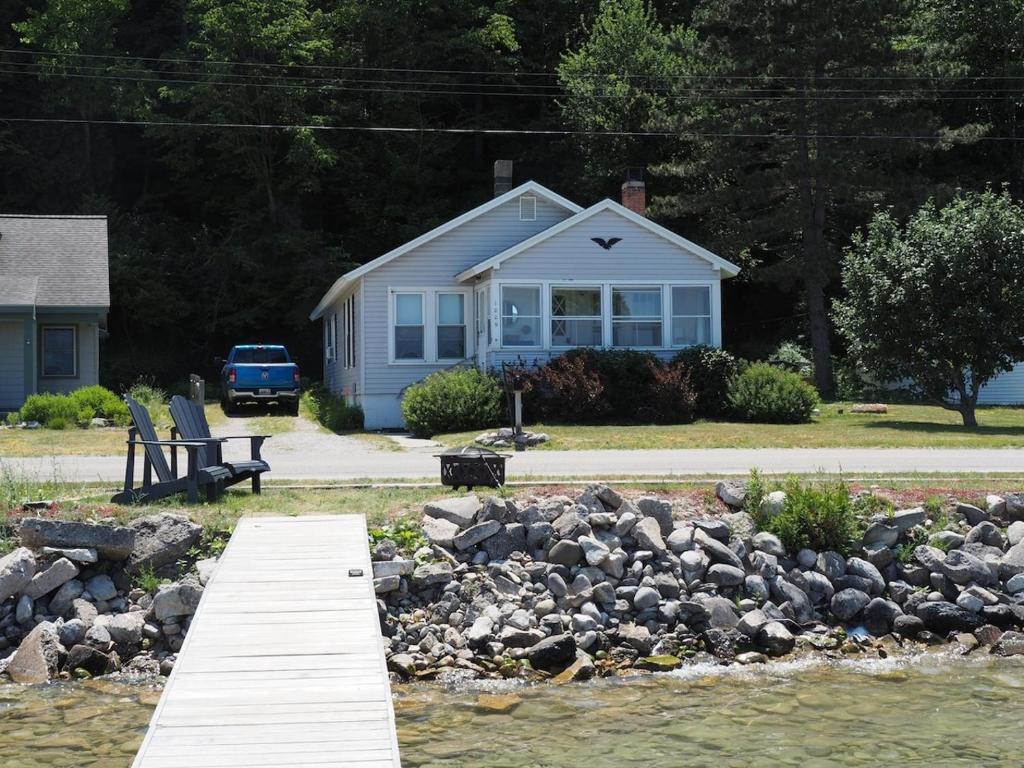 a house with a wooden dock in front of a body of water at The Bright And Breezy - Lakefront With Spa! in Frankfort