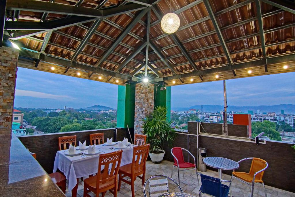 a dining room with a table and chairs with a view at 79 Living Hotel in Mandalay