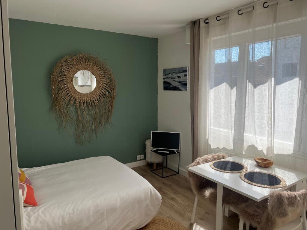 une chambre avec un lit, une table et un miroir dans l'établissement Baltimore, à Le Touquet-Paris-Plage